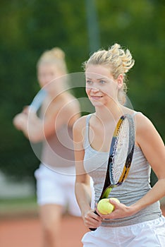 portrait women playing tennis doubles