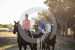 Portrait of women with trainer riding horse