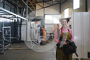 a portrait of a women welder holding a helmet and preparing for a working day in the metal industry