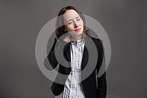 Portrait of wonderful young business woman has sore throat, poseing on isolated gray background