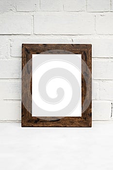 Portrait Wooden frame Mockup on white brick wall. PModern, minimal frame. Empty frame with space for text