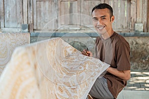 Portrait of a worker drawing batik pattern