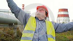 Portrait of worker, engineer relaxing in front of a power station and thinking about the future or weekend