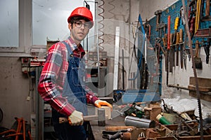 Portrait of a worker in a factory with working tools in the workbench