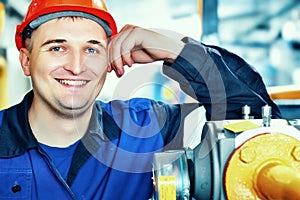 This is portrait of worker in helmet and clothes. Smiling engineer of Caucasian appearance in factory or industrial