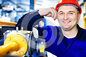 This is portrait of worker in helmet and clothes. Smiling engineer of Caucasian appearance in factory or industrial