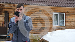 Portrait of the worker of the house which is carrying out an inspection by the thermal imager. To look for losses of