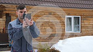 Portrait of the worker of the house which is carrying out an inspection by the thermal imager. To look for losses of