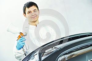 Portrait of worker painting auto car bumper