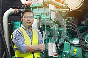 Portrait of worker or technician man hold wrench, smile and stand at generator room