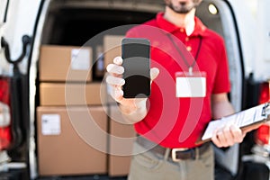 Portrait of a worker in a uniform holding a smartphone