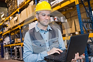 Portrait worker in warehouse with laptop computer