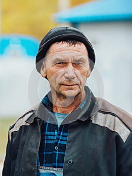 Portrait of working man on his chest. Genuinely tired worker builder in work clothes will look directly into cell.