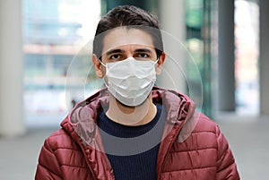 Portrait of worried man in modern city street wearing protective face mask