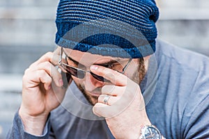 Portrait of a worried man with sunglasses talking on the phone - close up view