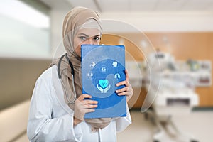 Portrait of worried muslim female Medical doctor holding paperclip