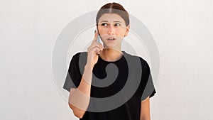 Portrait of worried young woman talking on mobile phone