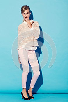 Portrait, wow and hand on mouth with a woman in studio on a blue background for surprise or shock. Fashion, gasp and