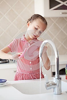 Little girl washing the dishes photo