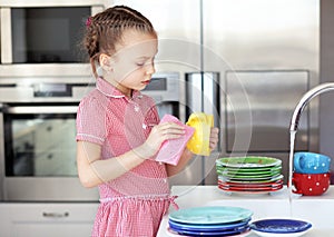 Little girl washing the dishes photo