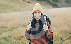 Portrait of a young activist female athlete tourist traveler with a heavy backpack on her back.