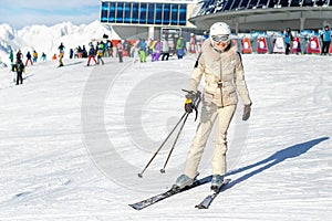 Portrait of young adult beautiful happy caucasian woman smiling near lift station at alpine winter skiing resort. Girl