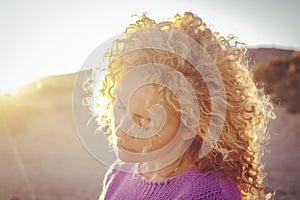 Portrait of young adult woman with closed eyes enjoying the sunlight in sunset outdoor. Life balance inner lifestyle female people