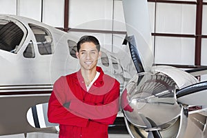 Portrait of young aeronautic engineer standing in front of an airplane propeller