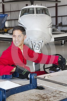 Portrait of young aeronautic engineer standing in front of an airplane propeller