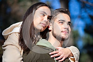 Portrait of young affectionate couple hugging in forest