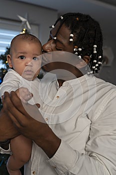 Portrait of young african american black father holding mulatto baby. Multiracial family concept and first baby