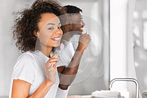 Portrait of young African American couple toothbrushing during morning routine
