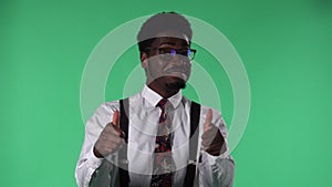 Portrait of young African American man looking at camera, smiling and showing thumbs up gesture. Black male with tie and