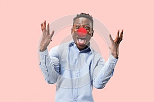 Portrait of young african-american man looks crazy happy. Red nose day celebrating