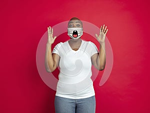 Portrait of young african-american woman with emotion on her protective face mask