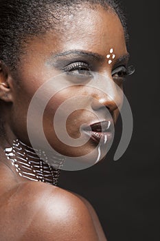Portrait of young african american woman with traditional white paint on face