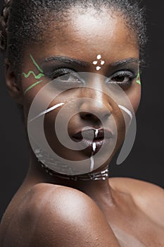 Portrait of young african american woman with traditional white paint on face