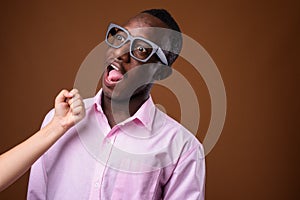 Portrait of young African businessman against brown background