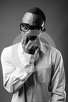 Portrait of young African businessman against gray background