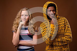 Portrait of young African man and Caucasian teenage girl thinking