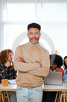 Portrait of young African man with his college mates studying in the background.