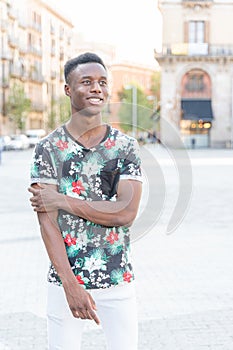 Portrait of young african man, outdoor with smartphine. Student and athletic man.