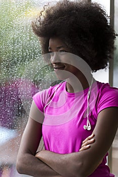 Portrait of young afro american woman in gym while listening mus