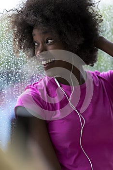 Portrait of young afro american woman in gym while listening mus