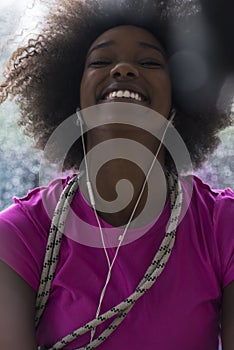 Portrait of young afro american woman in gym while listening mus