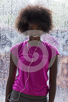 Portrait of young afro american woman in gym while listening mus