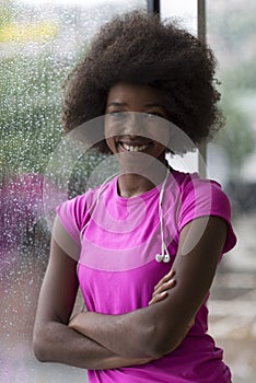 Portrait of young afro american woman in gym while listening mus