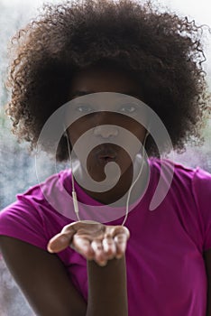 Portrait of young afro american woman in gym while listening mus