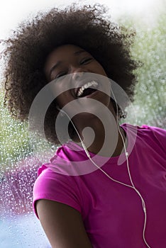 Portrait of young afro american woman in gym while listening mus