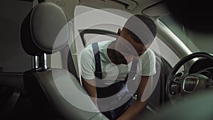 Portrait of a young afro american young man, a student who is dressed in special work clothes, earns money by washing